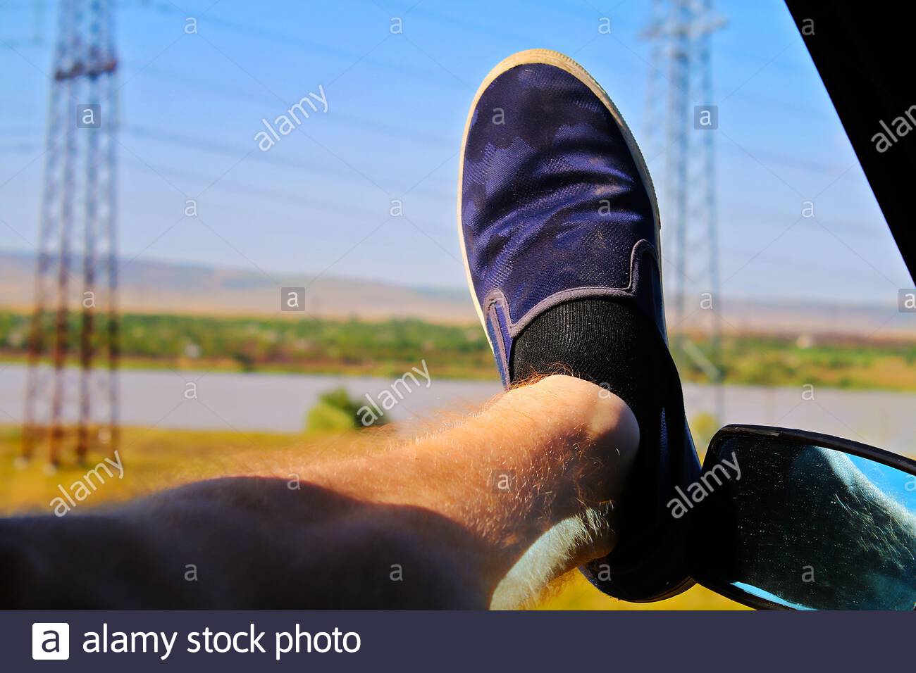 the-driver-put-his-foot-out-the-window-of-the-car-to-cool-it-summer-heat-heat-in-the-car-wind-...jpg